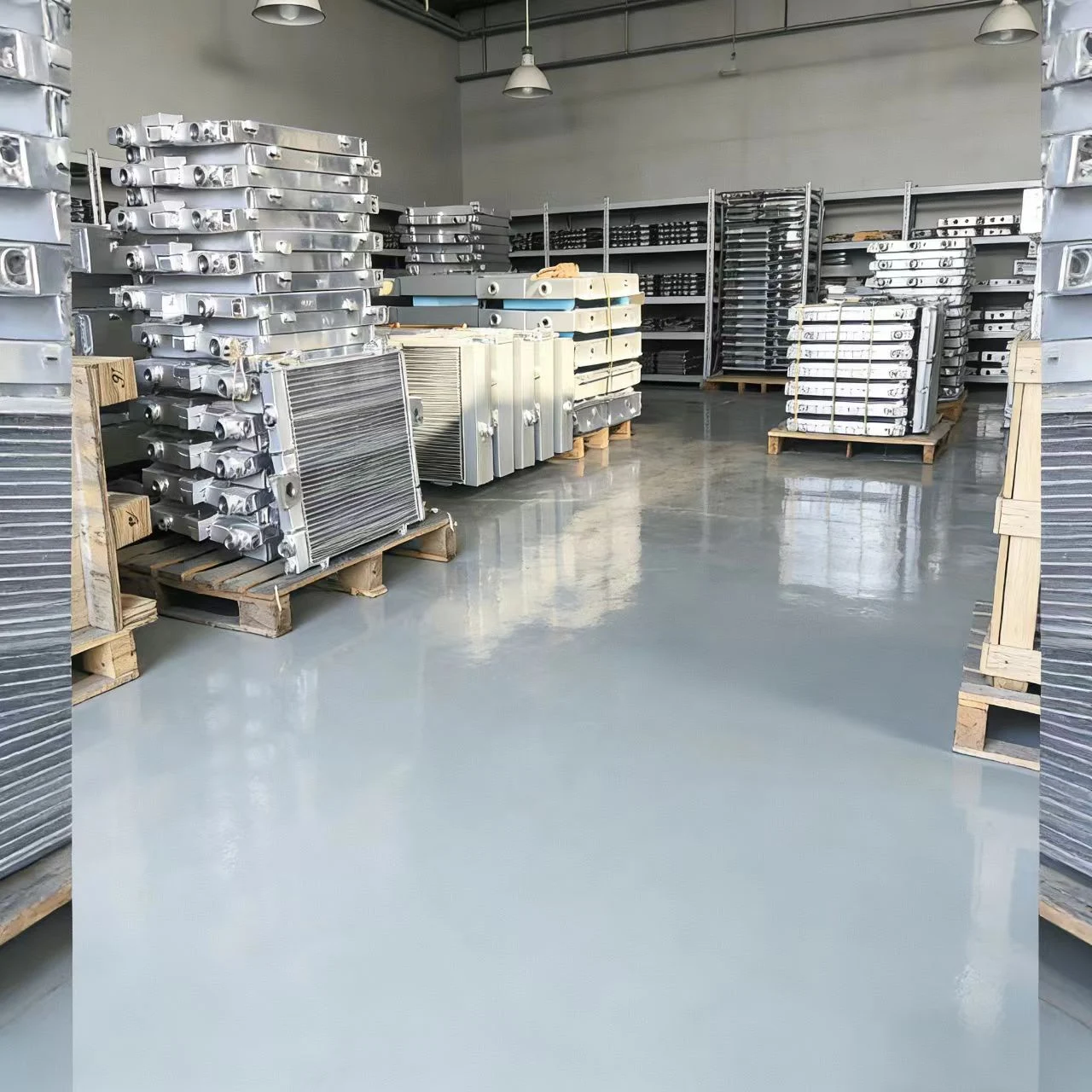 Batch of heavy-duty aluminum plate-fin radiators stacked on pallets in factory warehouse, ready for industrial engine cooling system assembly